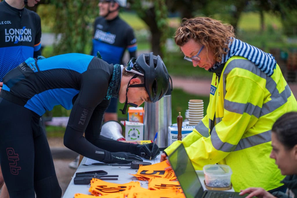 London Dynamo rider signing up for the hill climb event with a marshal helping out